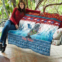 Blue Christmas quilt with manatee and Feliz Natal, draped over a seat outdoors