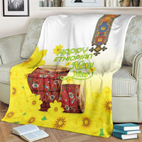 Yellow and white Ethiopian blanket with flower and drum print, draped on couch