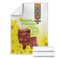 Yellow and white Ethiopian blanket with floral drum design, folded for display