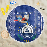 Personalized round beach blanket, blue with white fringe; coat of arms seal and bird.