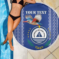 Personalized round beach blanket, blue with white fringe; coat of arms seal and bird.