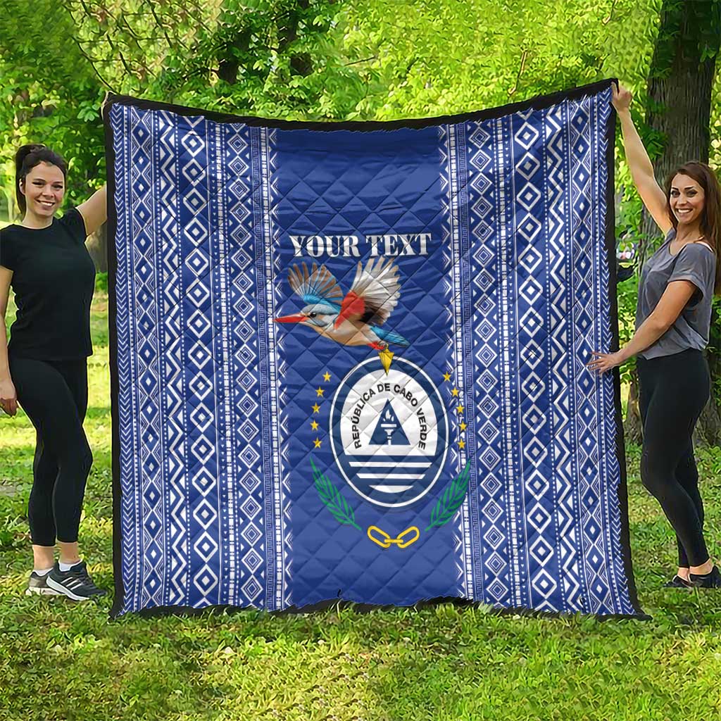 Blue personalized quilt with diamond pattern border and Cape Verde crest, laid flat