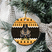 Orange round ceramic Anubis ornament on a tree with gold hanging loop and black figure