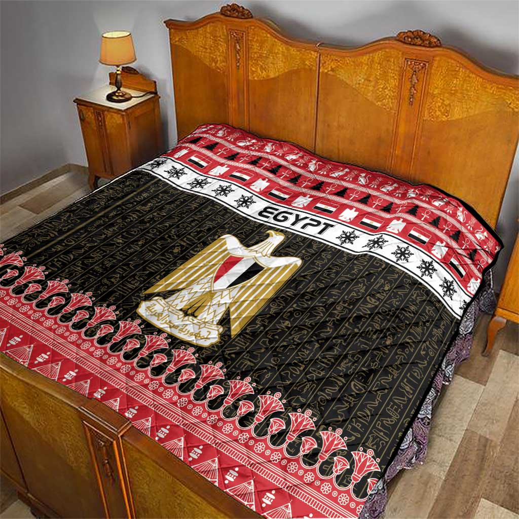 Egypt-themed quilt blanket on bed with red border, black pattern, and gold coat-of-arms artwork