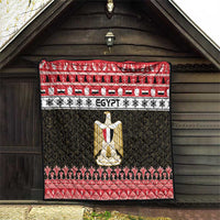 Egypt quilt blanket hung outdoors with red and black borders and gold coat-of-arms centerpiece