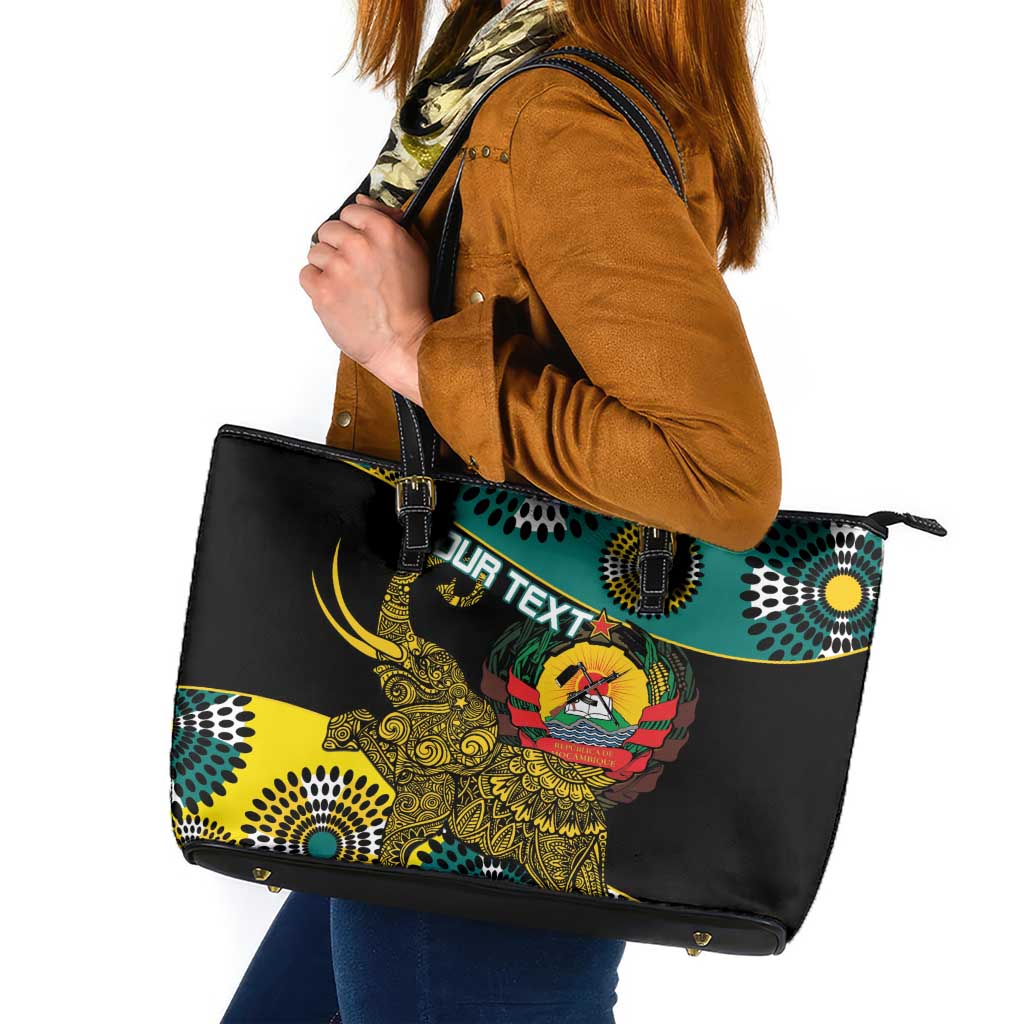 Black leather tote bag with top zip, teal and yellow African print, side angle