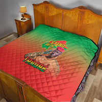 Green and red diamond-quilt blanket with 'I Stand With' and 'TRAORE' text on bed.