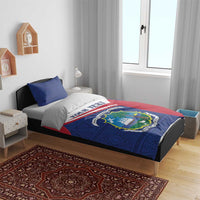 Personalized Liberia bedding set on bed: blue duvet with red/white band and “YOUR TEXT”.