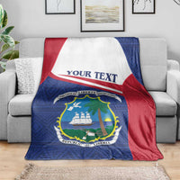 Liberia blanket coat on gray sofa, blue front with red and white top band