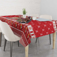 Red patterned Christmas tablecloth with llama and snowflake motifs, neatly laid on table.