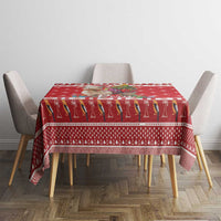 Red Christmas tablecloth with repeating llama figures and border stripe across table top.