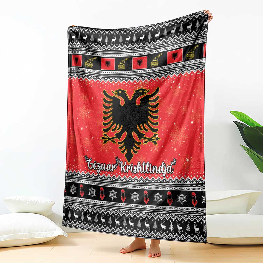 Red and black Christmas blanket draped on floor, featuring Albanian eagle and Gezuar Krishtlindja