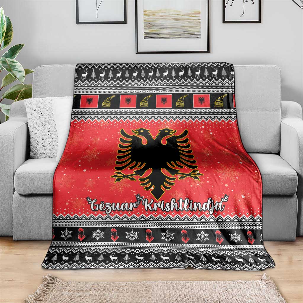 Red Christmas blanket over gray sofa, with Albanian eagle, festive icons, and black geometric trim