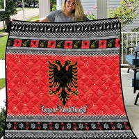 Red quilt blanket with black-and-white trim, Albanian eagle emblem, festive border text