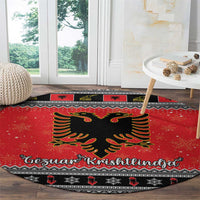 Red round Christmas rug with black eagle medallion and Gezuar Krishtlindja lettering