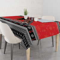 Red Christmas tablecloth with black Nordic-style pattern and trailing side drape.