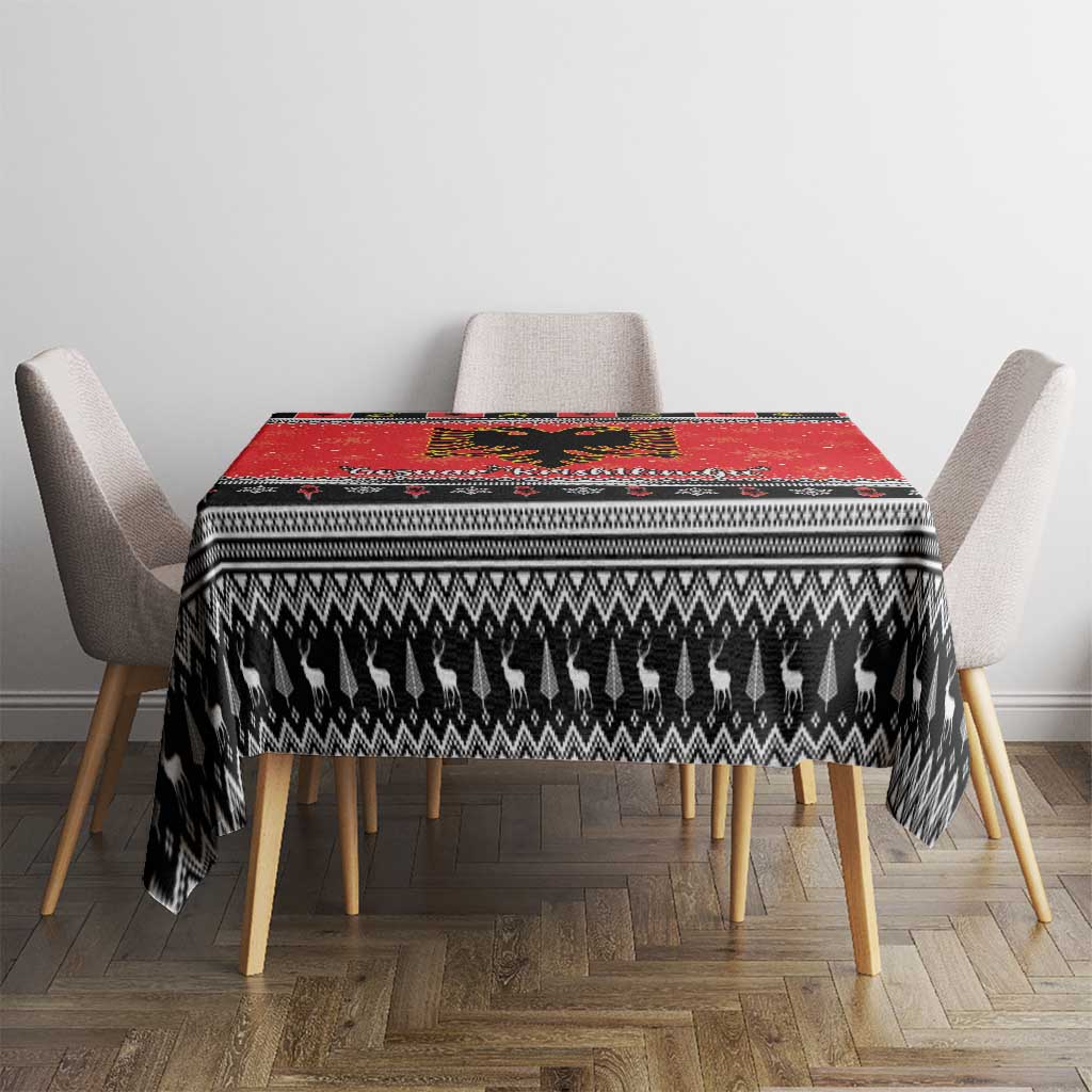 Red Christmas tablecloth on dining table with black geometric trim and hanging sides.