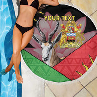 Black round beach blanket with white fringe edge, gazelle graphic, Malawi crest, 'YOUR TEXT'.