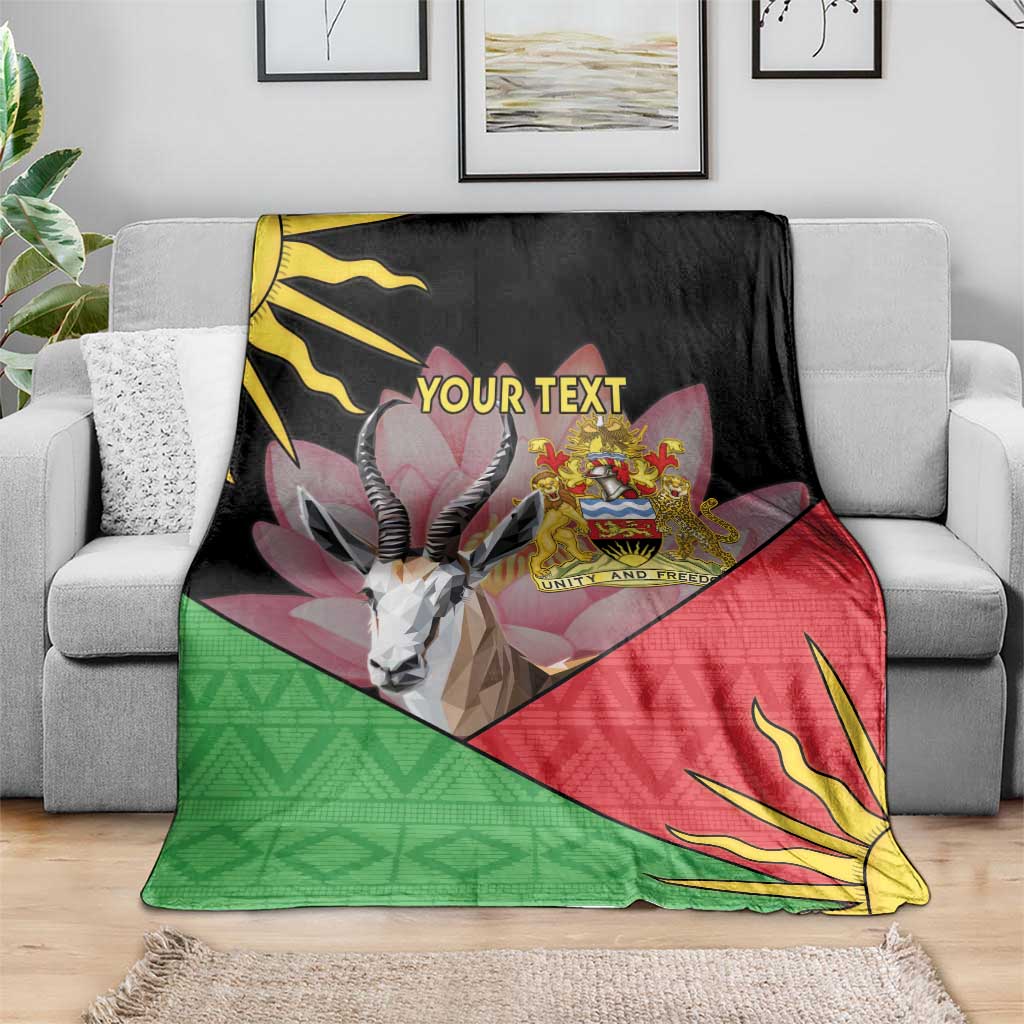Personalized black blanket draped over sofa with Malawi crest, antelope graphic, red/green pattern