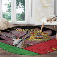 Round black area rug with African emblem, multicolor graphic, and custom text on floor