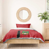Red football duvet with Malawi Football crest and black stripe, on bed.