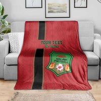 Red football blanket draped over sofa, black stripe and green crest with custom text.