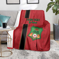 Red football blanket on sofa seat with black stripe and green crest logo, custom text.