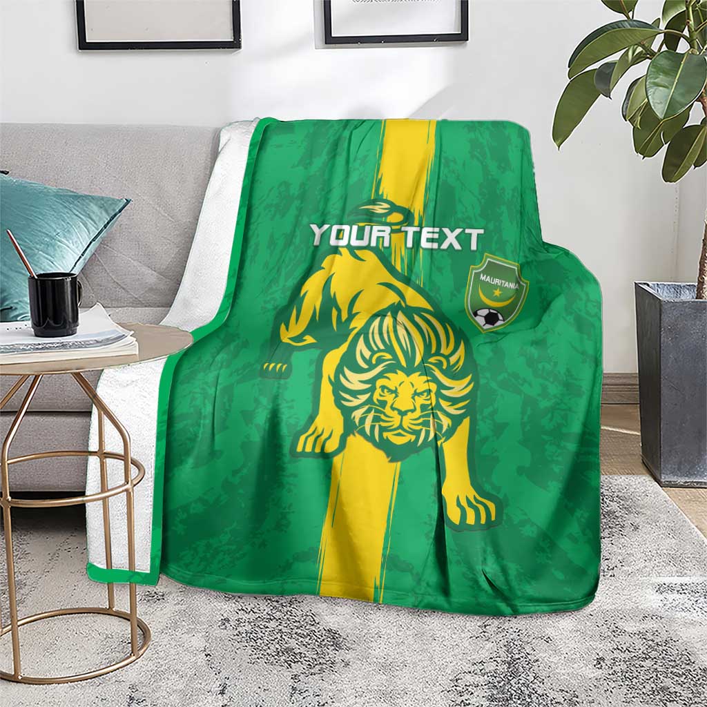 Green football blanket with yellow lion graphic and shield emblem, laid across floor rug