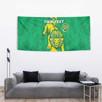 Green football tapestry with lion graphic, yellow stripe, crest, and YOUR TEXT, centered.