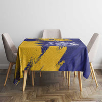 Tablecloth on small table with four chairs, blue and yellow crest flag print