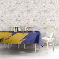 Tablecloth on long dining table with chairs, blue and yellow coat of arms design