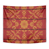 Close-up of red and gold patterned tapestry blanket with star and emblem motifs