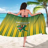 Green and yellow striped sarong with Dominica logo, worn open and held wide