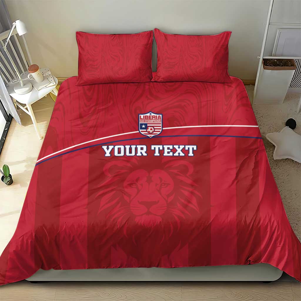 Red bedding set on bed with Liberia lion crest, white stripe, and two pillowcases