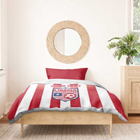 Red and white striped bedding set with red pillows and Liberia Football crest on top