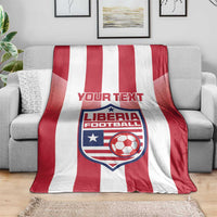 Red-and-white striped football blanket with Liberia crest and custom text on sofa