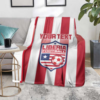Red-and-white striped football blanket with Liberia crest and custom text on floor