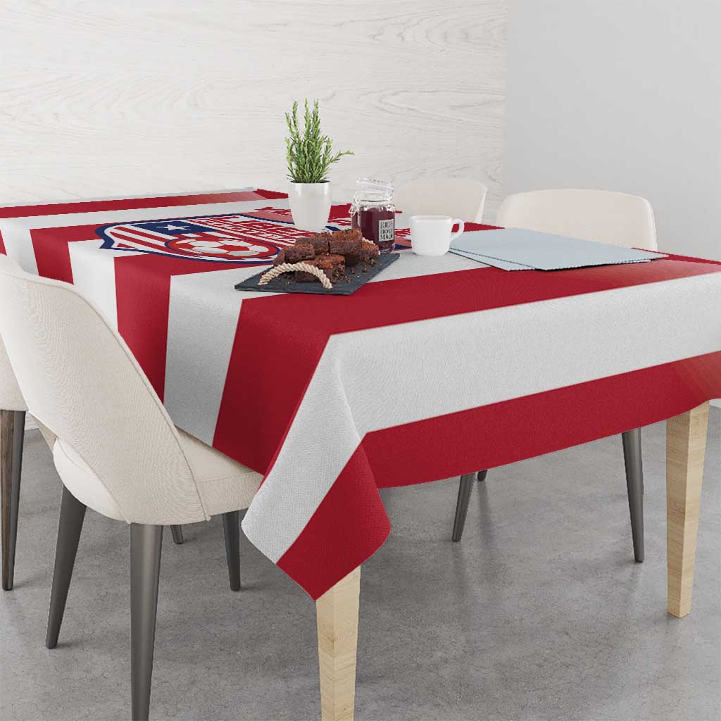 Red and white striped football tablecloth with crest on tabletop, draped edges.