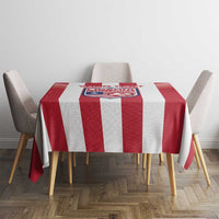 Red and white striped football tablecloth with crest panel on dining table surface.