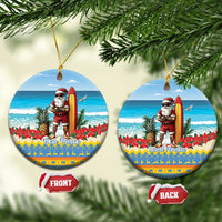 Blue round ceramic Christmas ornament with Santa surfing and “Bon Pasco” text.