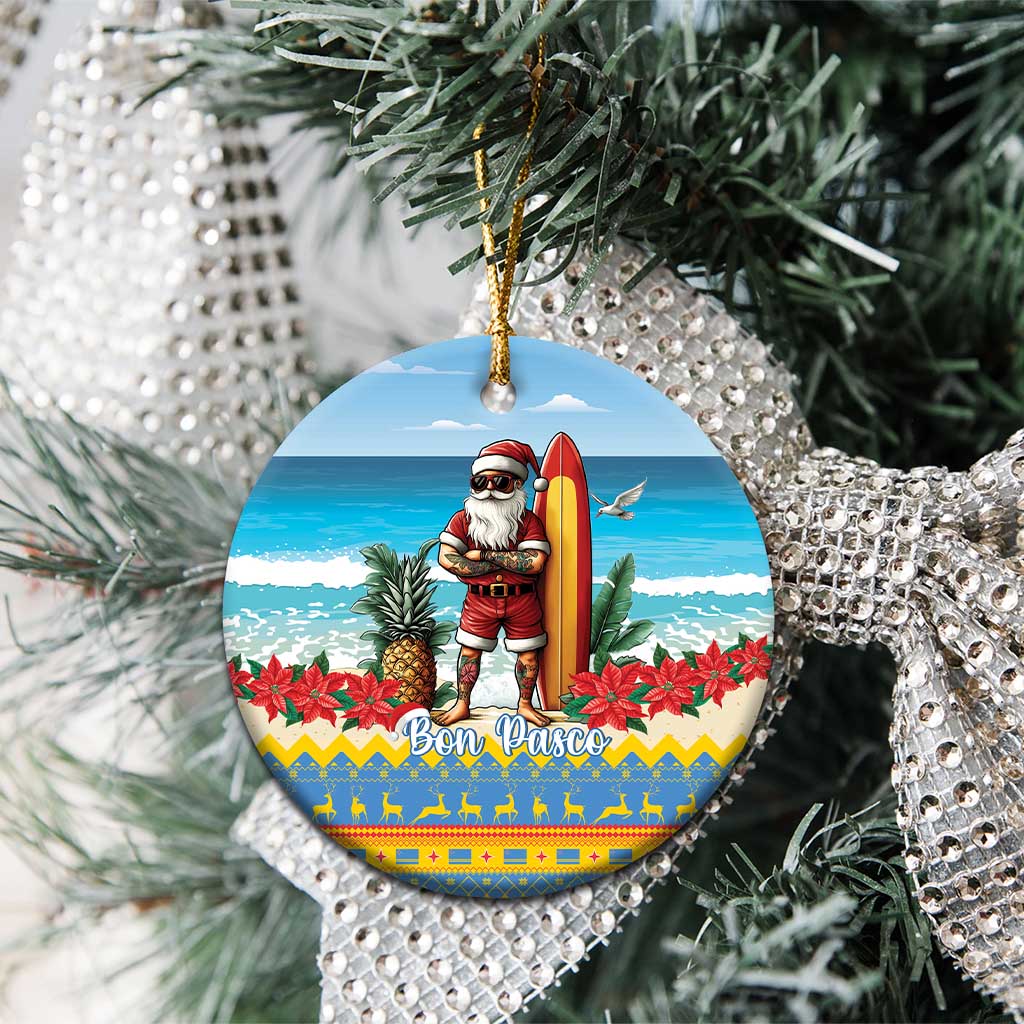 Blue round ceramic ornament on tree branches, Santa surfing with “Bon Pasco” design.