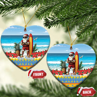 Two blue heart-shaped ceramic ornaments with Santa surfing; “Bon Pasco” and “Land Aruba” text.