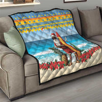 Blue throw quilt on a sofa with surfing Santa, “Bon Pasco” text and red poinsettias