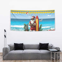 Christmas beach tapestry featuring Santa with surfboard and red floral plants on a sandy shoreline.