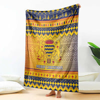 Christmas throw blanket with blue, gold, orange, and gray crest and “Merry Christmas”