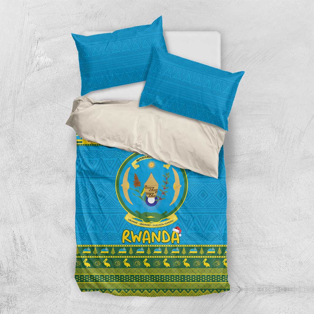 Blue Rwanda bedding set with emblem crest, green border, and two matching blue pillowcases