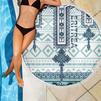 Round beach blanket near pool, white and teal geometric cross tile pattern, fringed edge