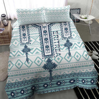 Teal and white geometric bedding set with central cross medallion and patterned borders