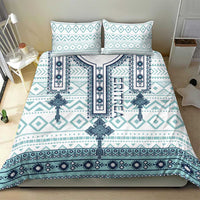 Teal and white cross-and-diamond duvet cover with two pillow shams on a bed
