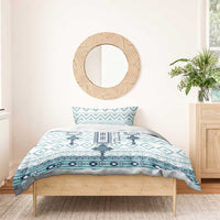 Teal and white cross patterned duvet cover with one pillow sham on a wooden bed frame